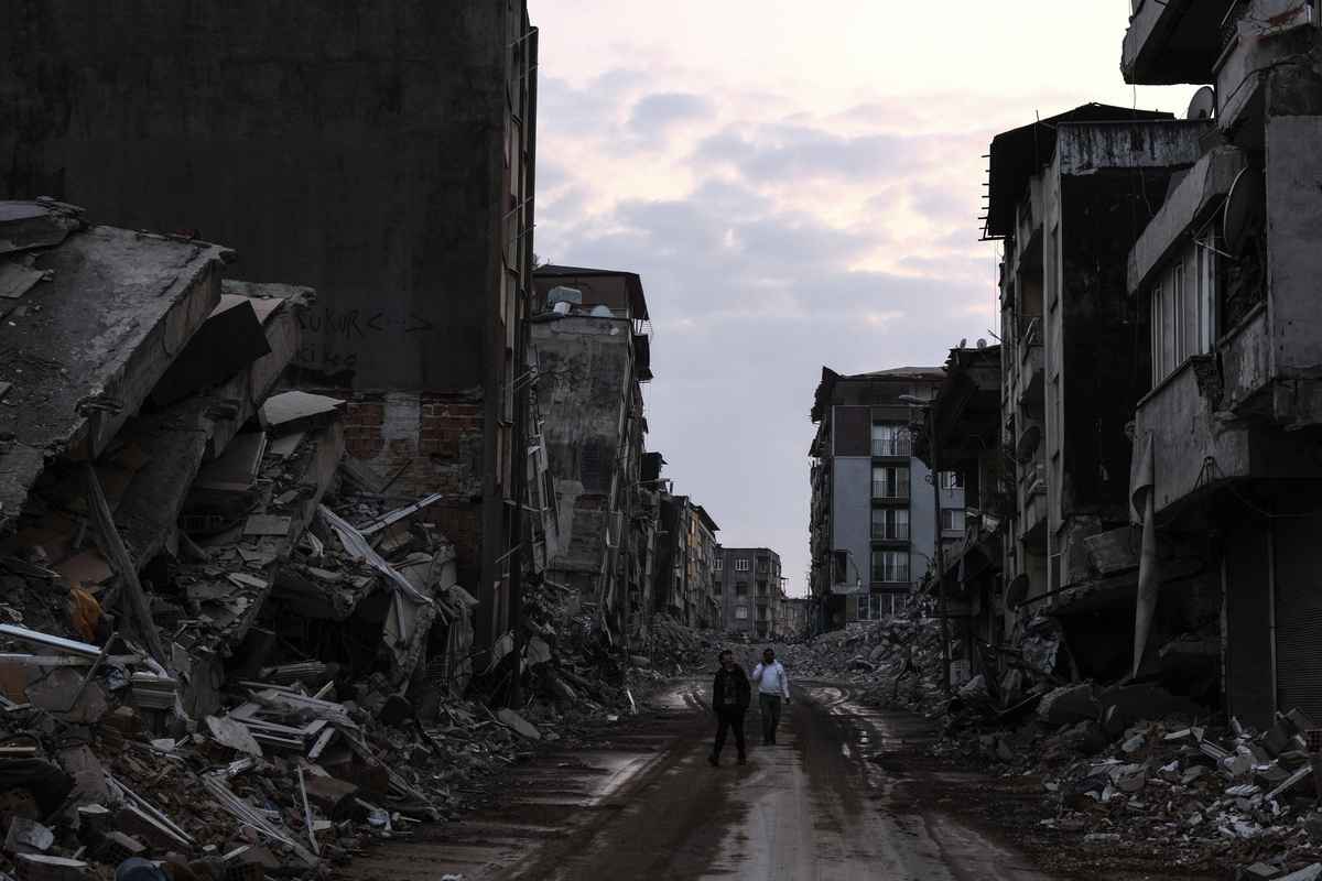 2023年2月24日，在土耳其哈塔伊省，當地人在被毀壞的建築之間行走。 （Mehmet Kacmaz/Getty Images）