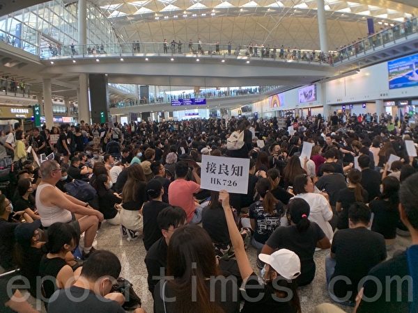 2019年7月26日，香港，一群航空界職員在香港機場的接機大廳舉行集會抗議，他們以派發傳單和手舉標語等方式向入境民眾反映香港人反送中的訴求。（李逸／大紀元）