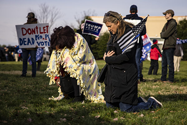 11月25日下午，賓夕凡尼亞州參議院在葛底斯堡溫德姆酒店舉行選舉問題聽證會。支持者在外面跪下祈禱。（Samuel Corum/Getty Images）