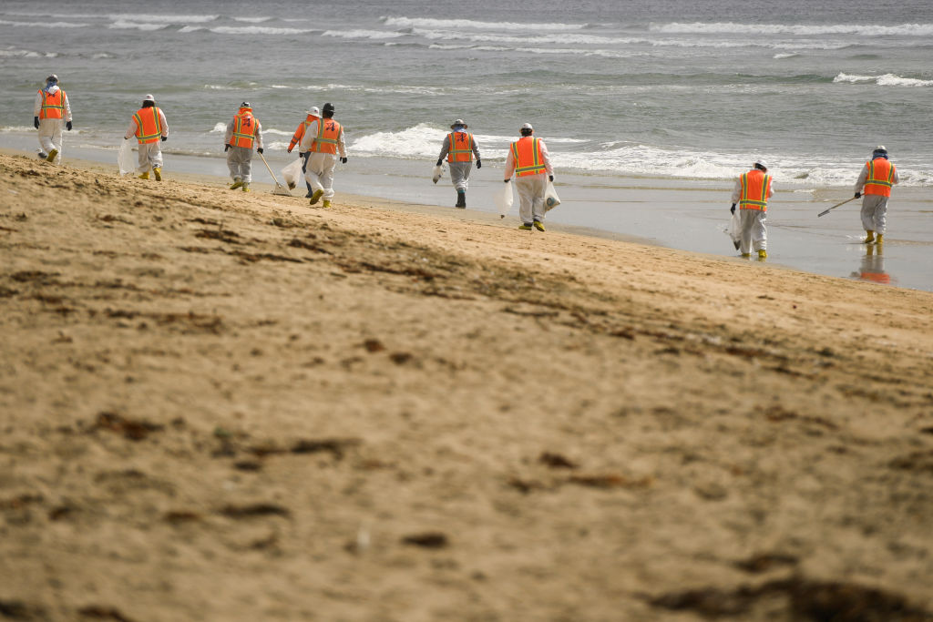 2021年10月4日，環境響應人員正在清理漏油事故後受到污染的加州亨廷頓海灘。（PATRICK T. FALLON/AFP via Getty Images）