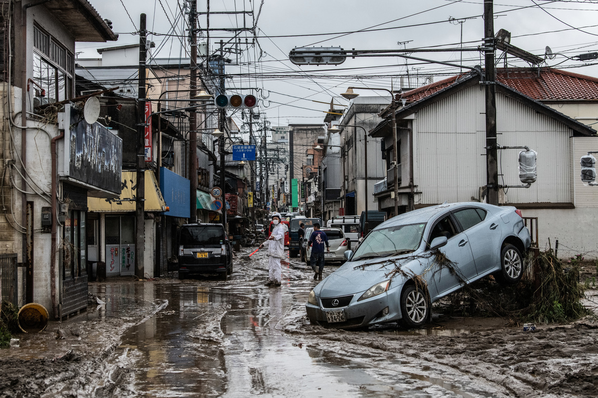 日本熊本縣周六（7月4日）降暴雨導致洪災和山泥傾瀉，造成至少20人死亡，14人失蹤。圖為2020年7月5日，日本熊本縣人吉市的一名警察站在泥水中指揮交通。（Carl Court/Getty Images）