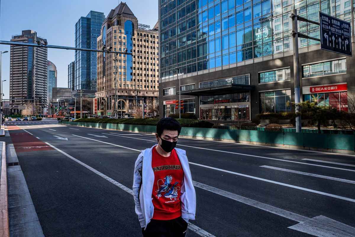2020年3月3日，一名男子戴着口罩在北京金融区的冷清街道上獨自一人行走。（Nicolas AsfouriI/AFP via Getty Images）