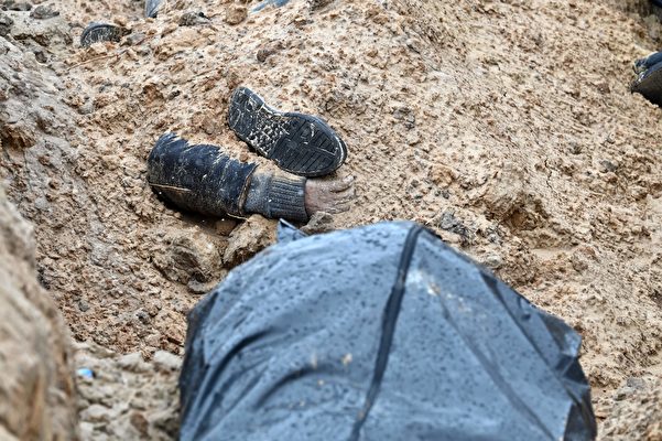 2022年4月3日，烏克蘭布恰鎮（Bucha）教堂後一條草草挖出的壕溝裏，發現了57具屍體，一些罹難者僅部份掩埋，露出手腳。（Sergei Supinsky/AFP via Getty Images）