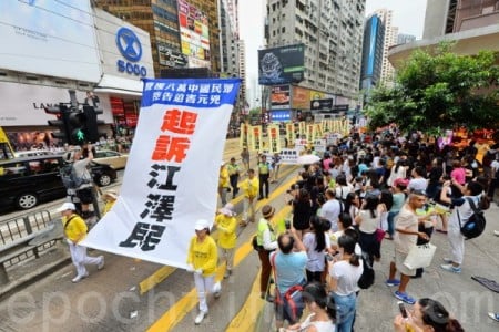 香港法輪功學員2015年7月19日舉行7.20聲援起訴江澤民大遊行，從北角到中聯辦，沿途吸引許多民眾觀看。（宋祥龍／大紀元）