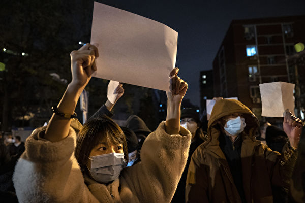 2022年11月27日，在北京，抗議者舉著白紙抗議中共嚴厲的清零政策。（Kevin Frayer/Getty Images）Images）