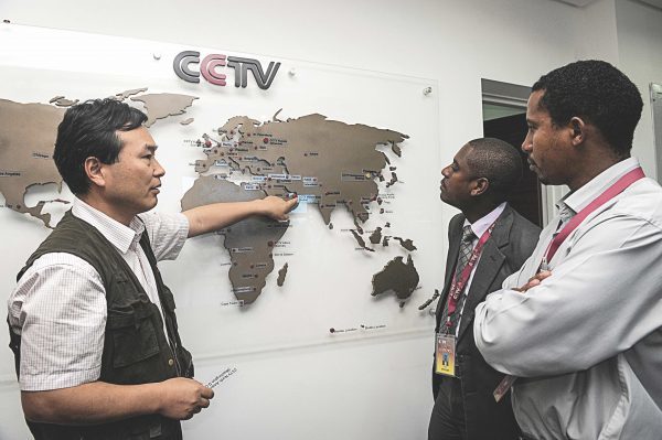 2012年6月12日，中國國際電視台非洲部執行總編龐新華（左）在肯雅內羅畢與當地記者交談，向他們展示該台如何在非洲不同地區擴展。（Simon Maina/AFP/GettyImages）