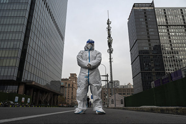 2022年11月22日，北京，一名防疫工作人員（俗稱大白）站在中央商務區中間的大道上。現在是上班高峰期，街道上幾乎空無一人，大多數人被要求待家中工作。（Kevin Frayer/Getty Images）