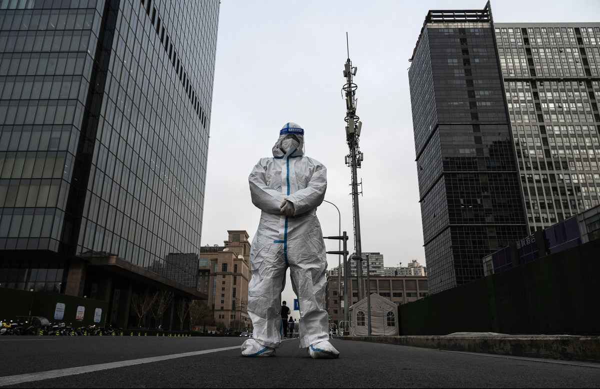 2022年11月22日，北京，一名防疫工作人員（俗稱大白）站在中央商務區中間的大道上。現在是上班高峰期，街道上幾乎空無一人，大多數人被要求居家辦公。（Kevin Frayer/Getty Images）