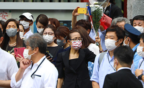 送安倍最後一程 旅日台僑拿花束及國旗致意日本前首相安倍晉三2022年7月8日遭槍擊身亡,震驚全球。12日安倍喪禮在增上寺舉行,大批民眾前來送別,有旅日台僑戴國旗口罩拿花束和國旗來感謝安倍對台灣的貢獻。(中央社)