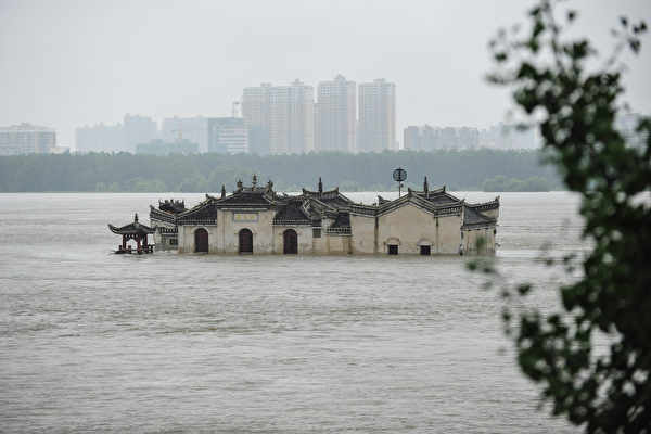 2020年7月19日，在湖北鄂州段長江中間的觀音閣（又名龍蟠磯寺），這座廟宇始建於1345年，坐落在浩瀚河流中的礁石龍蟠磯上。中共官方表示，自6月以來的大雨已經造成至少141人死亡和失蹤，僅在7月就迫使將近1500萬人從其家中撤離，並造成數十億美元的經濟損失。 （STR/AFP via Getty Images）