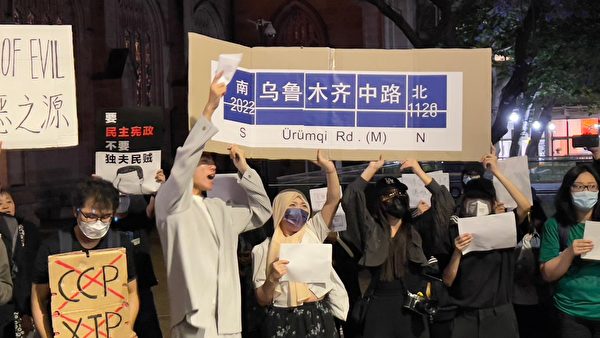 抗議者高舉仿製上海「烏魯木齊路」的路牌。（凌霄／大紀元）