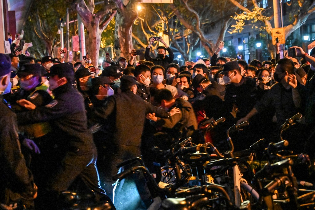 2022年11月27日，在上海的抗議活動中，警察和警衛逮捕了一名男子。（HECTOR RETAMAL/AFP）