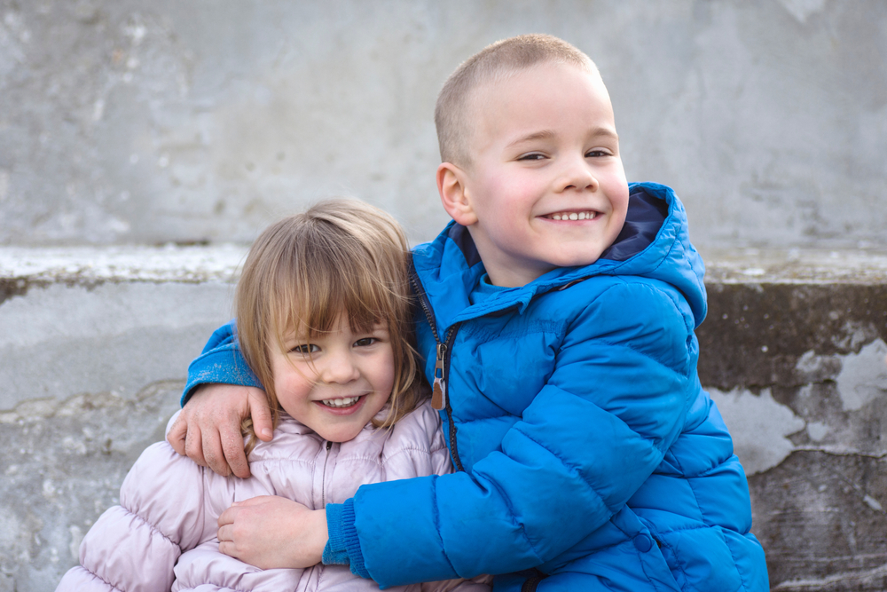 笑容可愛的小妹妹和大哥哥在一起。（Shutterstock）