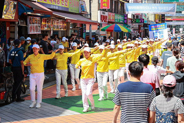 遊行隊伍經過南韓首爾中國人聚居地，參與者向群眾展示功法。（李裕貞／大紀元）