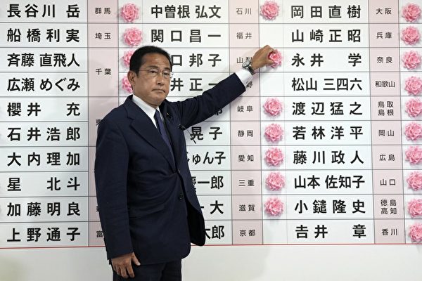 圖為2022年7月10日，在參議院的選舉中，自民黨總裁、日本首相岸田文雄在當選候選人的名字上放花。（TORU HANAI/POOL/AFP）