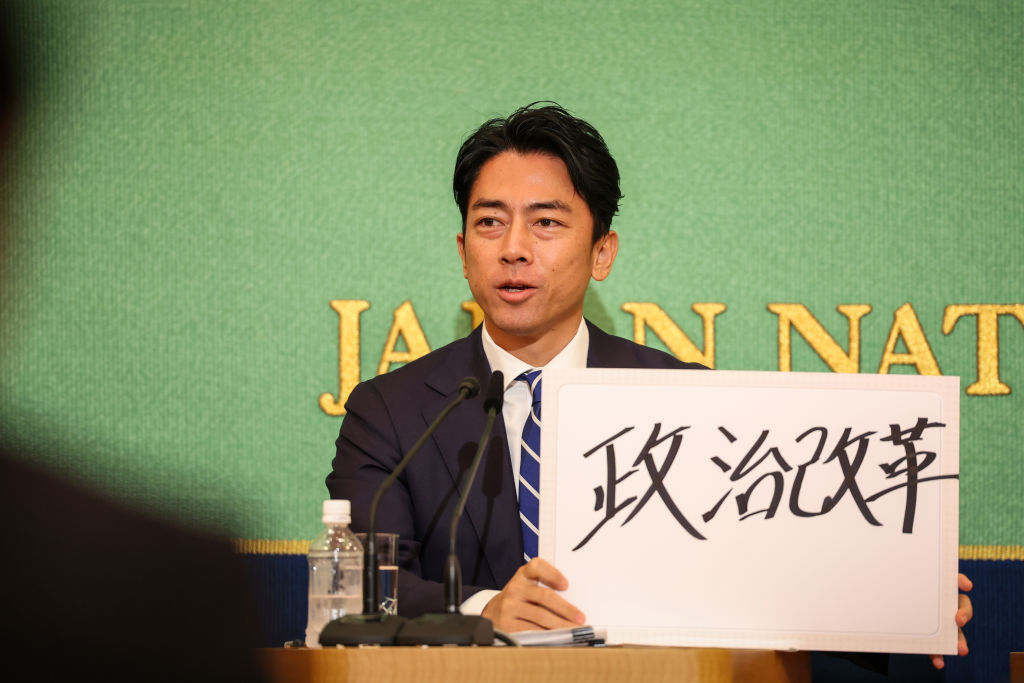 2024年9月14日,日本東京,日本執政黨自民黨(LDP)總統大選候選人、前環境大臣小泉進次郎在日本記者俱樂部(Nixon Kisha Club)的一場辯論中手舉標語。(Takashi Aoyama/Getty Images)