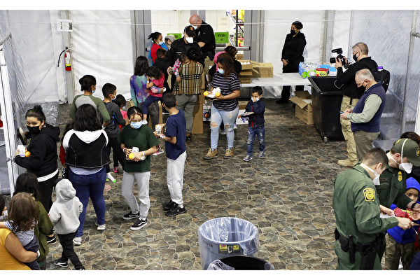 2021年3月17日，美國海關與邊境保衛局（CBP）位於德州Donna的臨時受理中心，被收容的無監護人陪伴未成年人和非法越境的家庭正在排隊領取食物。（美國CBP）
