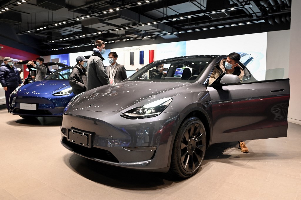 汽油價格的飆升推動人們對電動汽車的需求。圖為2021年1月5日，人們在北京的Tesla展廳觀看一輛TeslaModel Y汽車。（WANG Zhao/AFP）