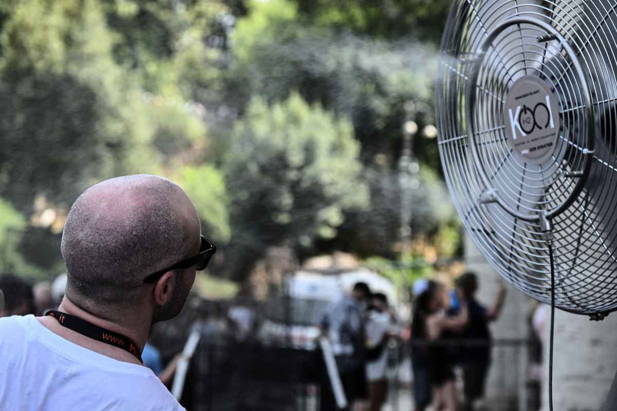 2023年7月18日，在羅馬的熱浪中，一名遊客在進入羅馬體會技場前，在大風扇前乘涼。在熱浪和野火炙烤下，歐洲迎來了接近創紀錄的高溫，北半球有大片地區因野火燒燬。 （TIZIANA FABI/AFP via Getty Images）