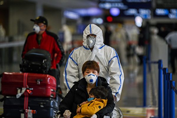 2020年3月19日，戴著口罩的旅客抵達上海浦東國際機場。（Hector Retamal/AFP via Getty Images）
