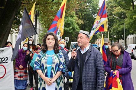 2021年10月4日,位於德國慕尼黑的安聯集團總部前,多個人權組織和民間團體聚集,抗議安聯集團贊助北京冬奧會。圖為受中共迫害的維吾爾西迪克女士(Qelbinur Sidik)和東突歐洲主席禪先生(Asgar Can)介紹會談情況。(黃芩/大紀元)
