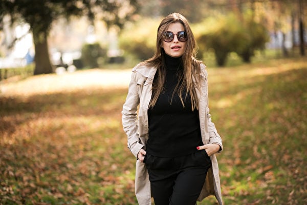黑高領配黑色彈力褲，外套米白色風衣，墨鏡，簡約時尚，活力四射。（Shutterstock）