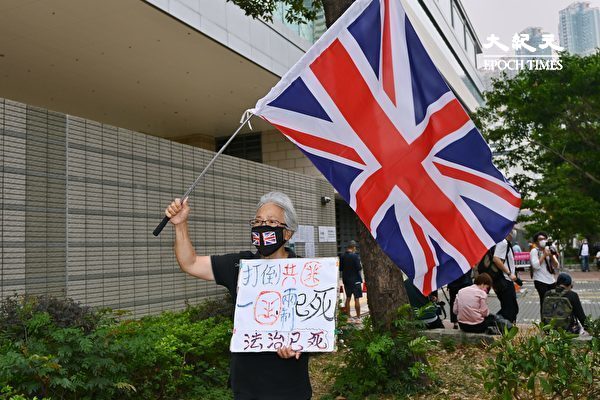 2021年4月16日，香港「8.18集會」與「8.31集會」案進行宣判程序。香港王婆婆舉著英國國旗前來聲援。（宋碧龍／大紀元）