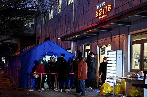 2022年12月21日，北京疫情高峰期間，一發熱門診外排隊候診的病人。（Jade Gao/AFP）