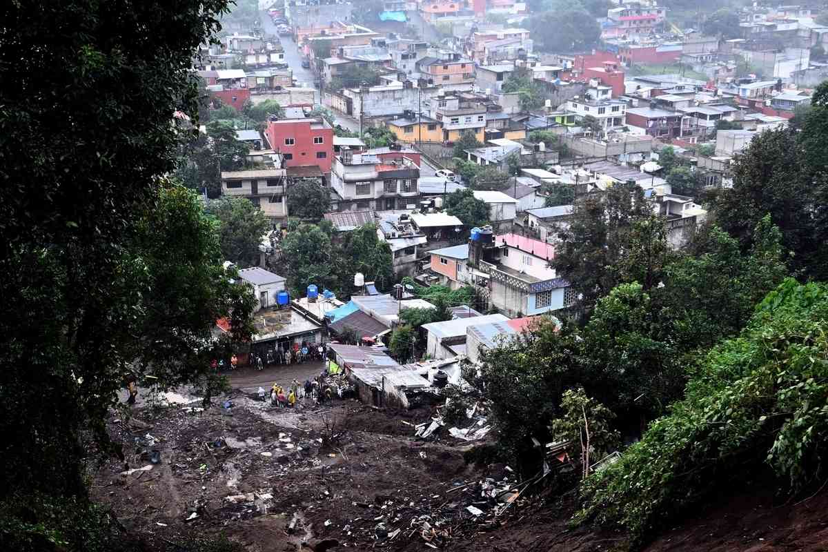 2025年10月11日,墨西哥普埃布拉州瓦烏奇南戈市(Huauchinango)遭暴雨襲擊後,蒙特雷(Monterrey)一社區附近發生大規模山泥傾瀉,多棟民宅遭到損毀。圖為人們正在現場進行清理工作。(Alfredo Estrella/AFP via Getty Images)