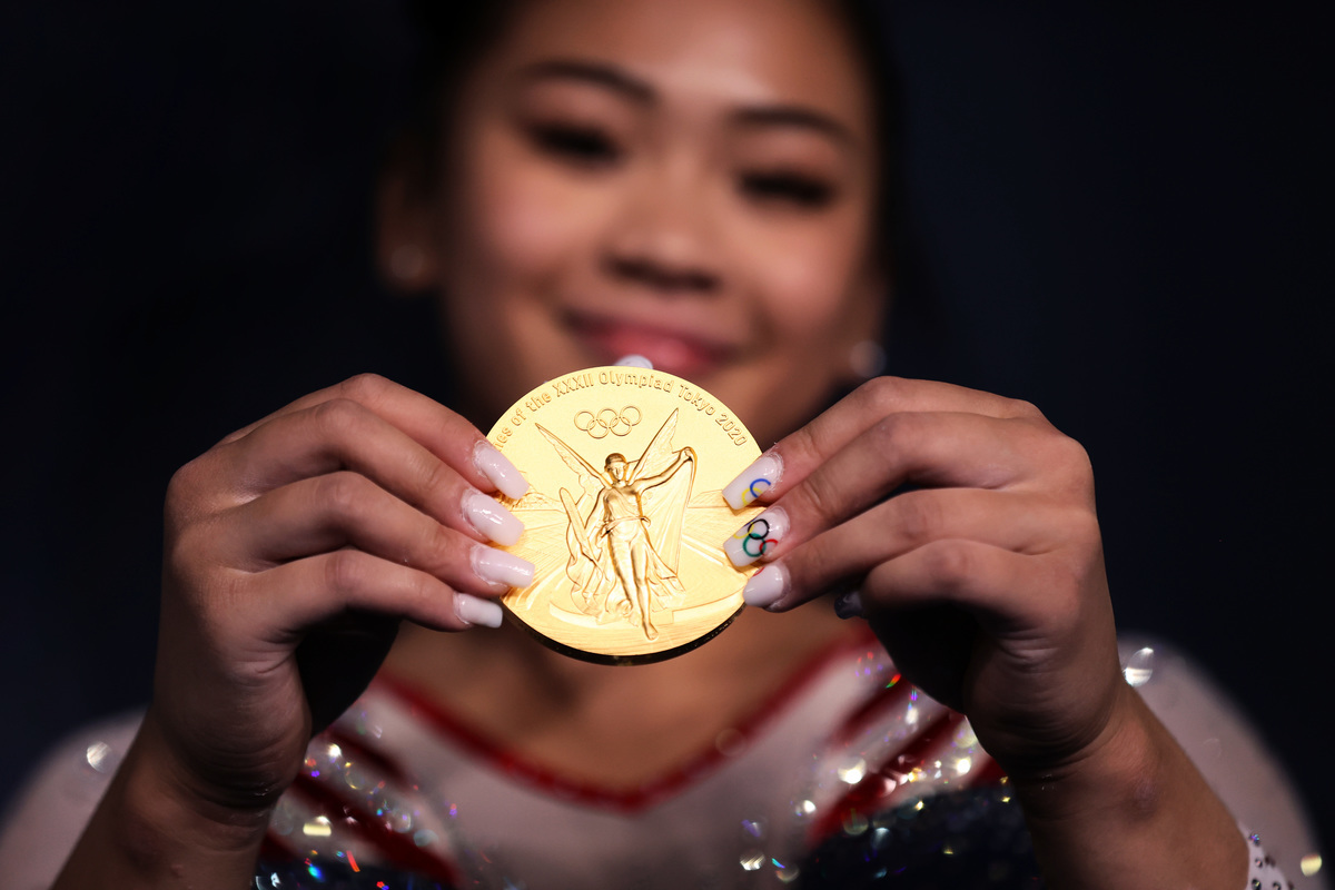2021年7月29日，美國隊體操選手蘇妮莎‧李（Sunisa Lee）在贏得女子全能決賽後手持金牌的畫面。（Laurence Griffiths/Getty Images）