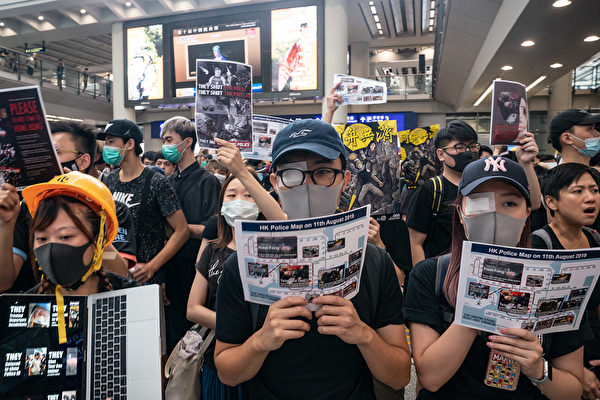 8.11一位少女被射穿右眼，8月12日港人在機場矇右眼抗議。（Anthony Kwan/Getty Images）