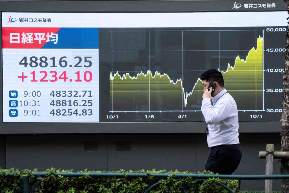 2025年10月20日,日本東京證券交易所外,一名男子走過顯示日經指數的電子屏幕。受自民黨與日本維新會結盟消息激勵,日經指數飆升近3%,創下歷史新高。(KAZUHIRO NOGI/AFP via Getty Images)