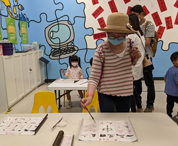 2022年7月2日，家長與小孩體驗香港節的書法教室。（徐曼沅／大紀元）