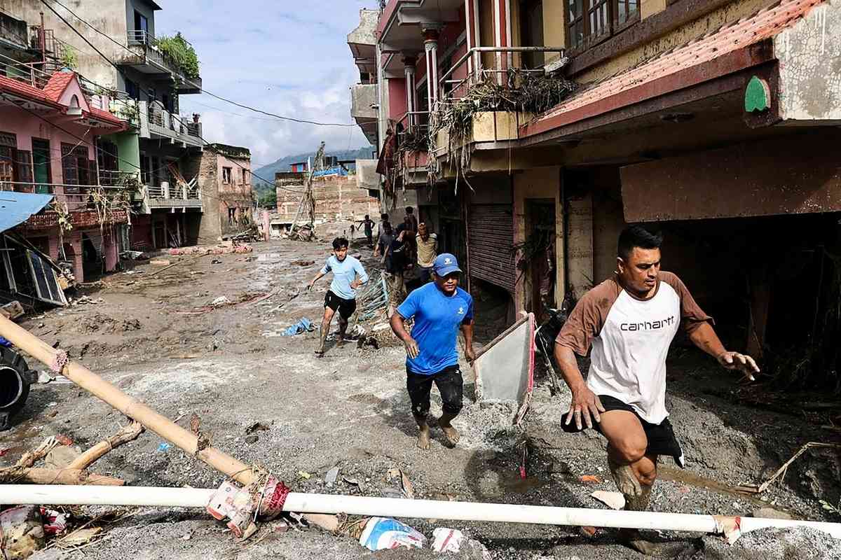 2026年8月27日，尼泊爾努瓦科特縣（Nuwakot）德夫加特（Devghat）的許多房屋被淤泥掩埋，當地居民赤腳走過布滿泥水的街道。（Prabin Ranabhat/AFP via Getty Images）