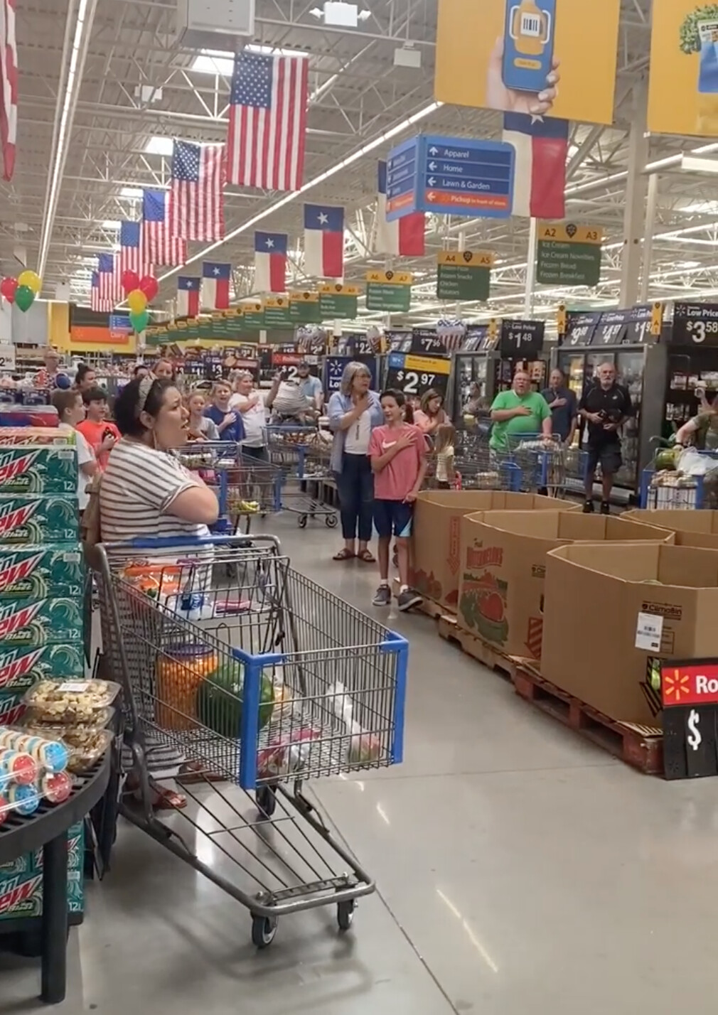 一位站在超市門口的購物者看到頭上方一面巨大的美國國旗，於是情不自禁高聲唱起美國國歌。（顧客施拉格提供）