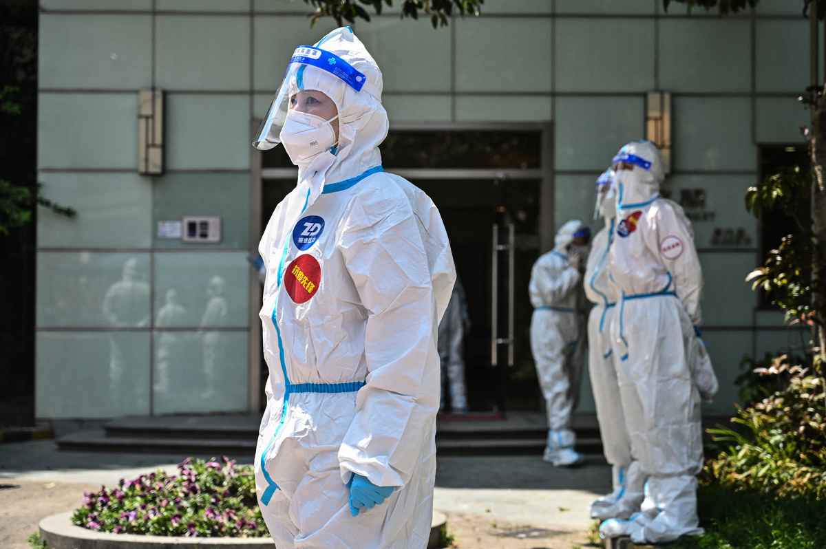 2022年4月6日上海靜安區一處冠狀病毒檢測站的醫護人員及義工。（Hector Retamal/AFP）