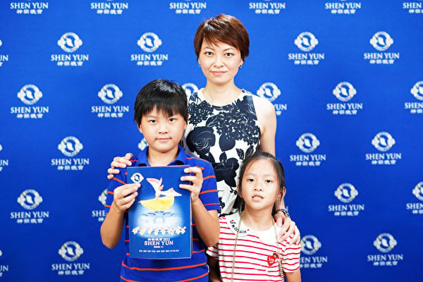 公司負責人李世華與孩子，觀賞2022年6月29日下午神韻國際藝術團在台中市中山堂的演出。（龔安妮／大紀元）