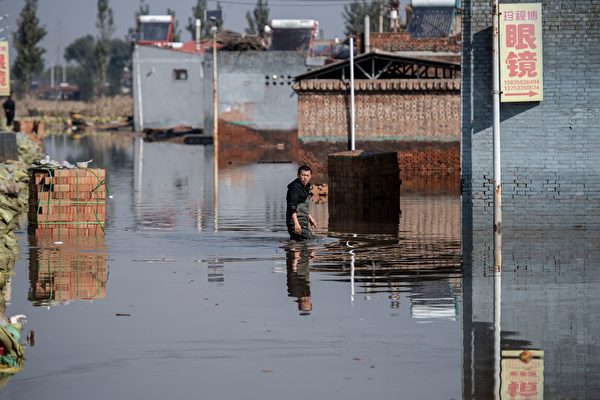 2021年10月11日，中國山西省晉中市介休市，暴雨造成洪災，一位市民涉水通行。（AFP via Getty Images）