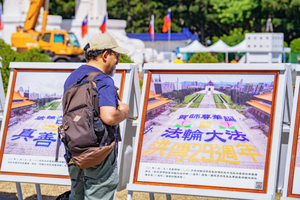 2025年10月18日,來自台灣、美加日韓、香港等地的部份法輪功學員逾5,000人,在台北中正紀念堂自由廣場舉辦排字活動。圖為民眾觀看法輪功真相看板。(趙郁誠/大紀元)