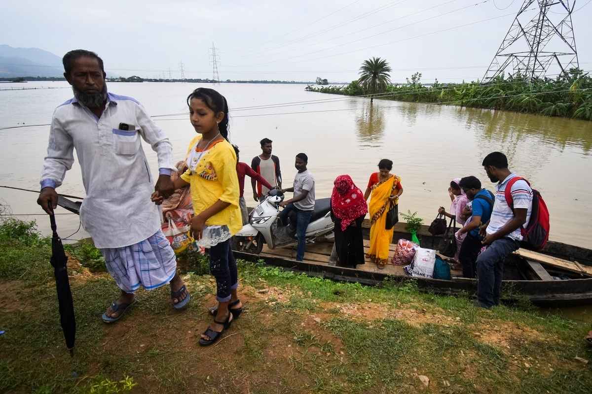 2025年6月3日,印度阿薩姆邦霍賈伊區(Hojai district)發生嚴重洪澇,人們帶著物品,乘坐小船轉移至安全地帶。(Anuwar Hazarika/Middle East Images/AFP via Getty Images)