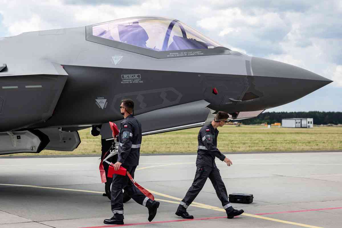 2026年6月12日，波蘭拉斯克 （Lask）第32戰術空軍基地（32nd Tactical Air Base），波蘭訂購的首批三架美國洛歇馬丁製造的F-35「閃電II」戰鬥機抵達該基地，地勤人員站在其中的一架（在波蘭服役時被命名為「驃騎兵/Husarz」）旁邊。這架飛機當天正式在波蘭空軍服役。（Wojtek Radwanski/AFP via Getty Images）
