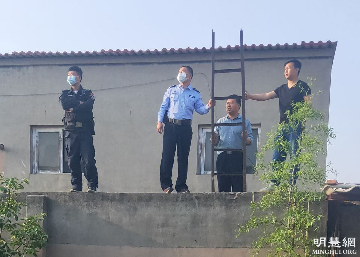 石家莊市深澤縣四個警察搬梯子翻上院牆，試圖綁架法輪功學員劉英傑。（明慧網）