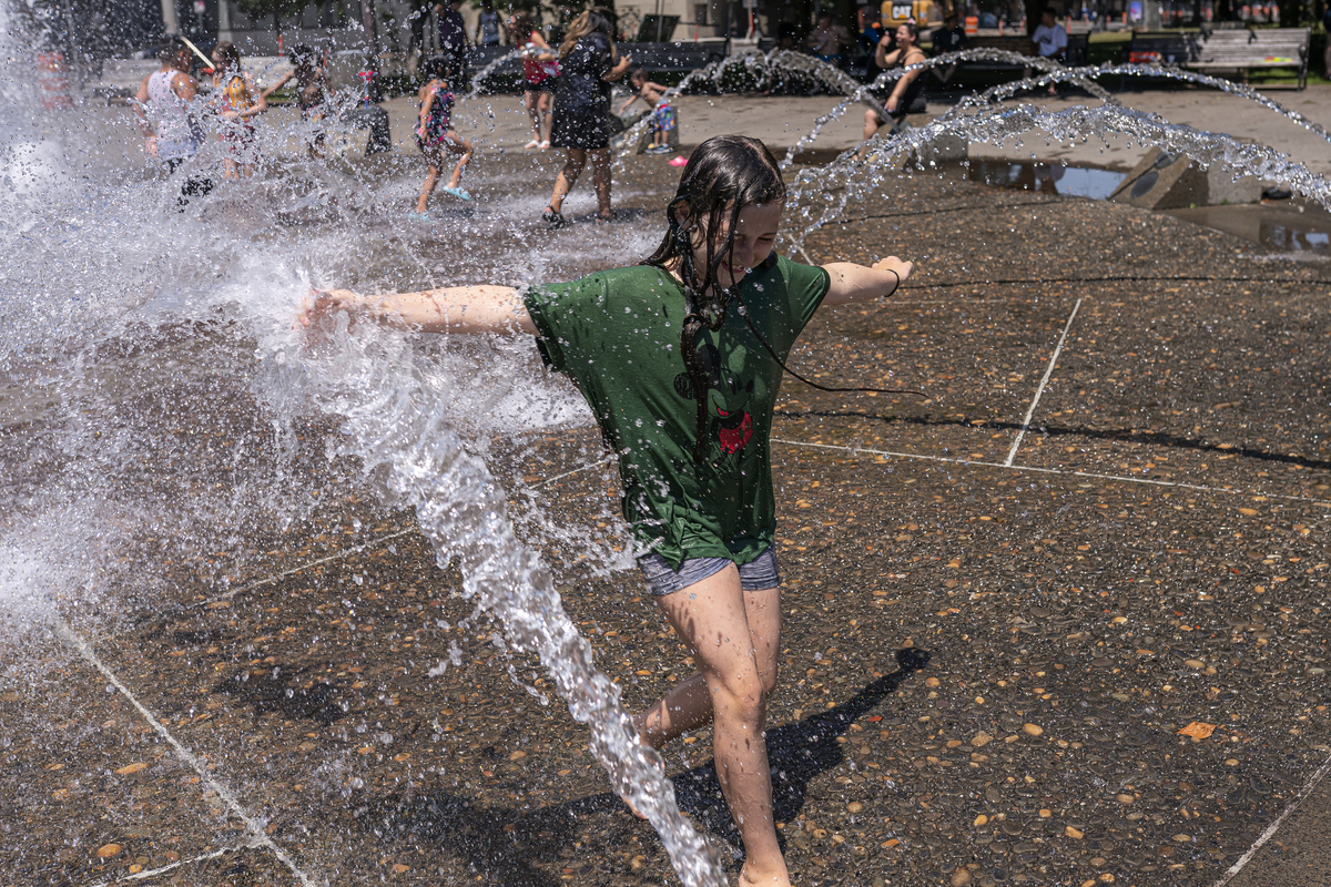 2021年6月27日，在俄勒岡州波特蘭，孩子們在三文魚泉（Salmon Springs）噴泉水中玩耍。在本周末的歷史性熱浪中，破紀錄的溫度在西北地區上空徘徊。 （Nathan Howard/Getty Images）