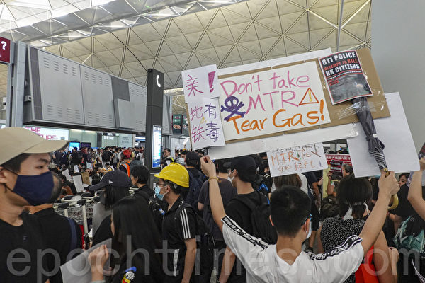 2019年8月12日，港人在香港機場展開「警察還眼」集會，民眾以「地鐵有毒」、「不要搭地鐵 」等中英文展板和標語抗議港警發射催淚彈。（余鋼／大紀元）