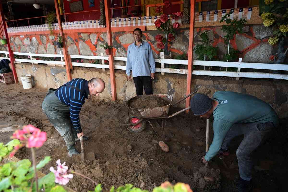 2026年8月17日，智利阿塔卡馬大區（Atacama）科皮亞波省卡爾德拉公社的別霍港（Puerto Viejo）因極端暴雨引發嚴重的泥石流災情，當地居民在清理住宅中的淤泥和垃圾。（Patricio Banda/AFP via Getty Images）