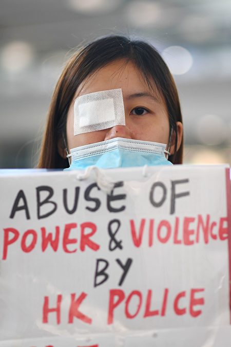 8.11一位少女被射穿右眼，8月12日港人在機場矇右眼抗議。（VATSYAYANA/AFP/Getty Images）