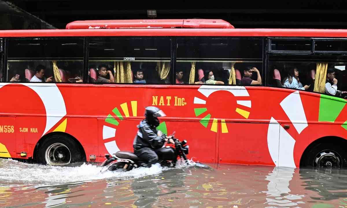 2026年8月17日，在菲律賓首都馬尼拉，多條街道因短時強降雨而嚴重積水，民眾被迫涉水而行。（Ted Aljibe/AFP via Getty Images）