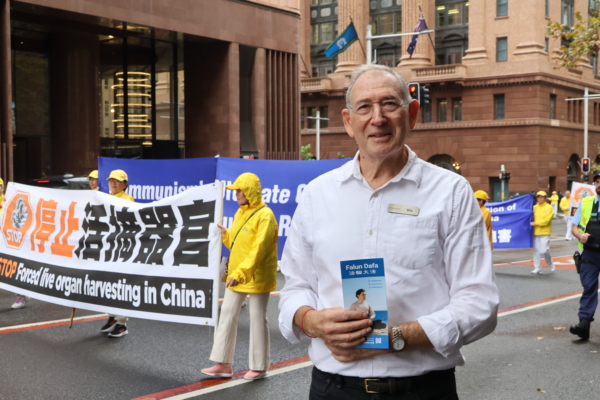 2025年5月8日中午,悉尼法輪功學員舉行一年一度的盛大遊行,慶祝「5.13世界法輪大法日」暨法輪大法洪傳世界33周年及法輪功創始人李洪志大師的華誕。圖為觀看遊行的雅各布先生(Mr. Jacobs)。(文清揚/大紀元)