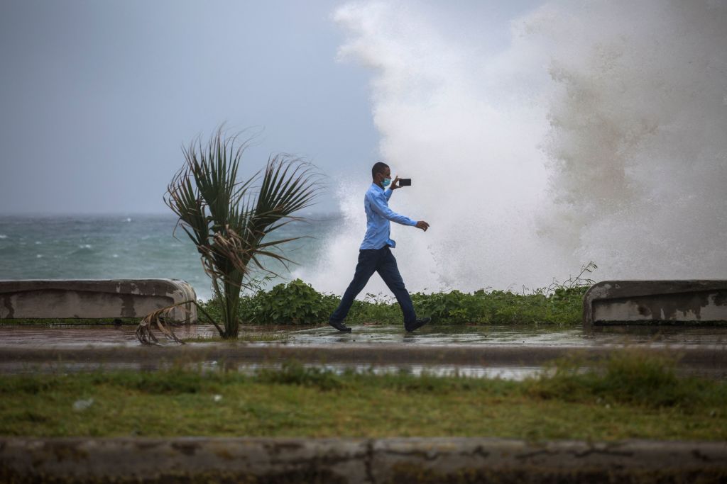 2021年7月3日，熱帶風暴「艾爾莎」（Elsa）來襲期間，多米尼加共和國聖杜明高地區一男子拍攝強浪場景。（ERIKA SANTELICES/afp/AFP via Getty Images）