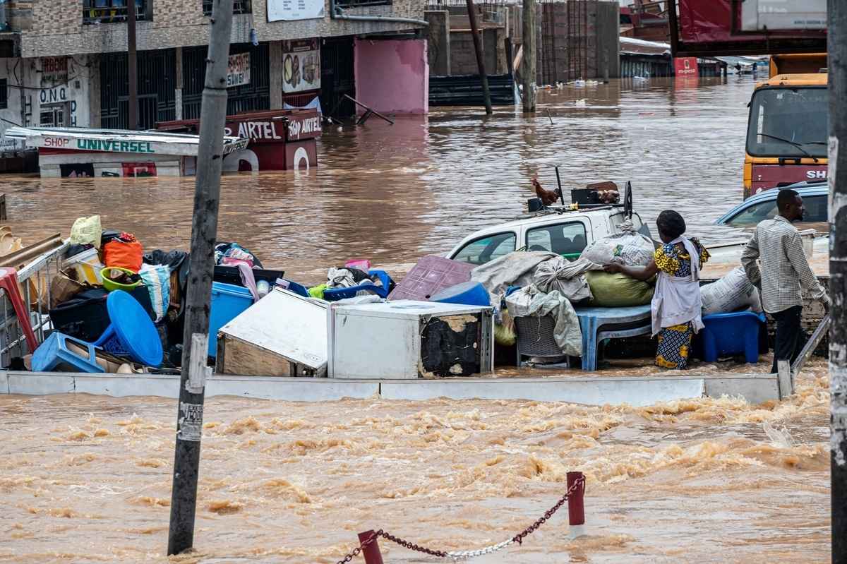 2025年4月6日,民主剛果首都金沙薩恩吉利區(Ndjili district)遭到暴雨襲擊,一條道路被洪水淹沒,居民設法將財物轉移到安全地帶。(Hardy Bope/AFP via Getty Images)